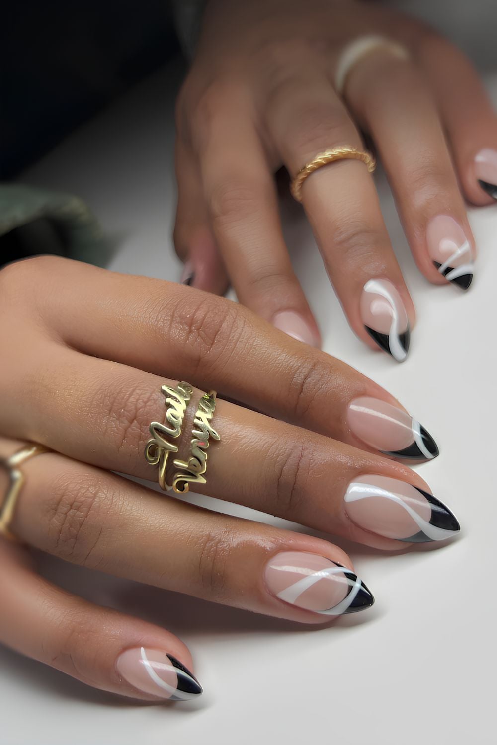 Black French nails with white swirl accents