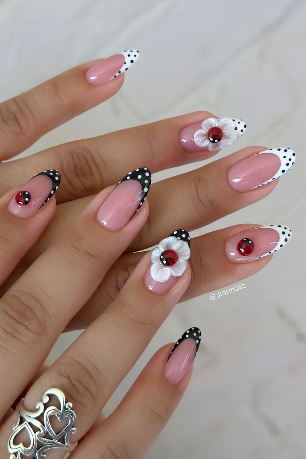 Black and white polka dot nails with lady bug on a sculpted flower design
