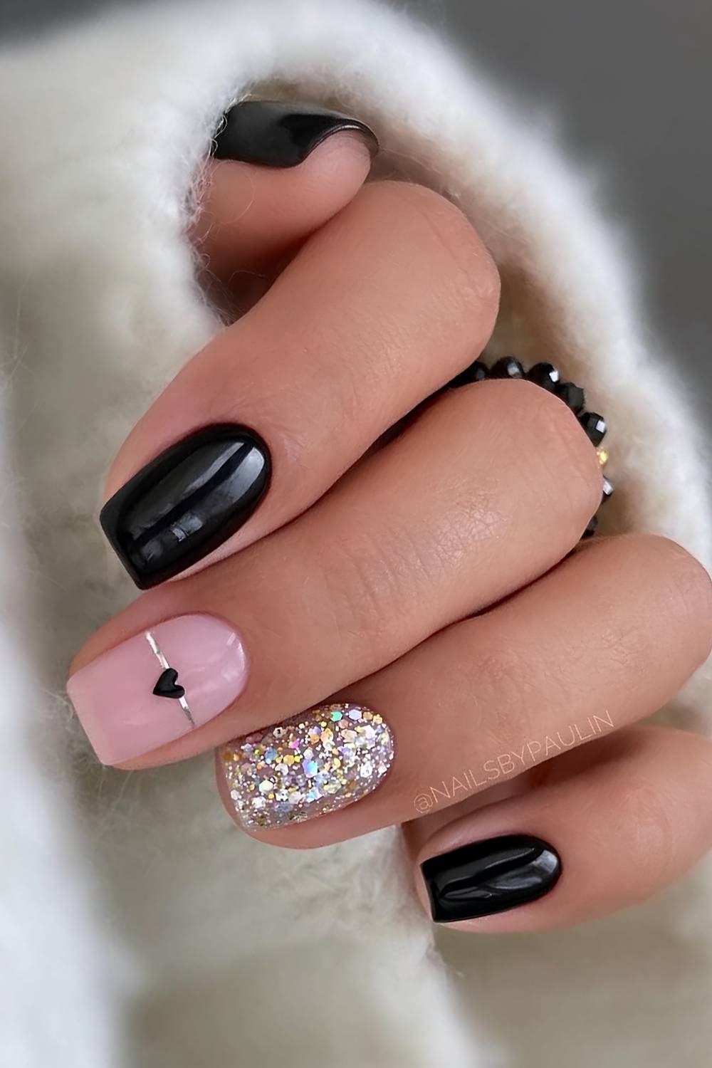 Black manicure with hearts and glitter