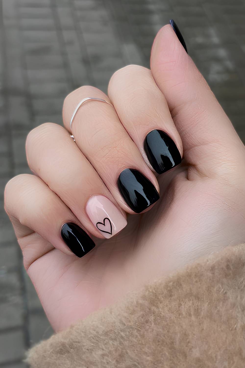 Black nails with a heart on an accent nail
