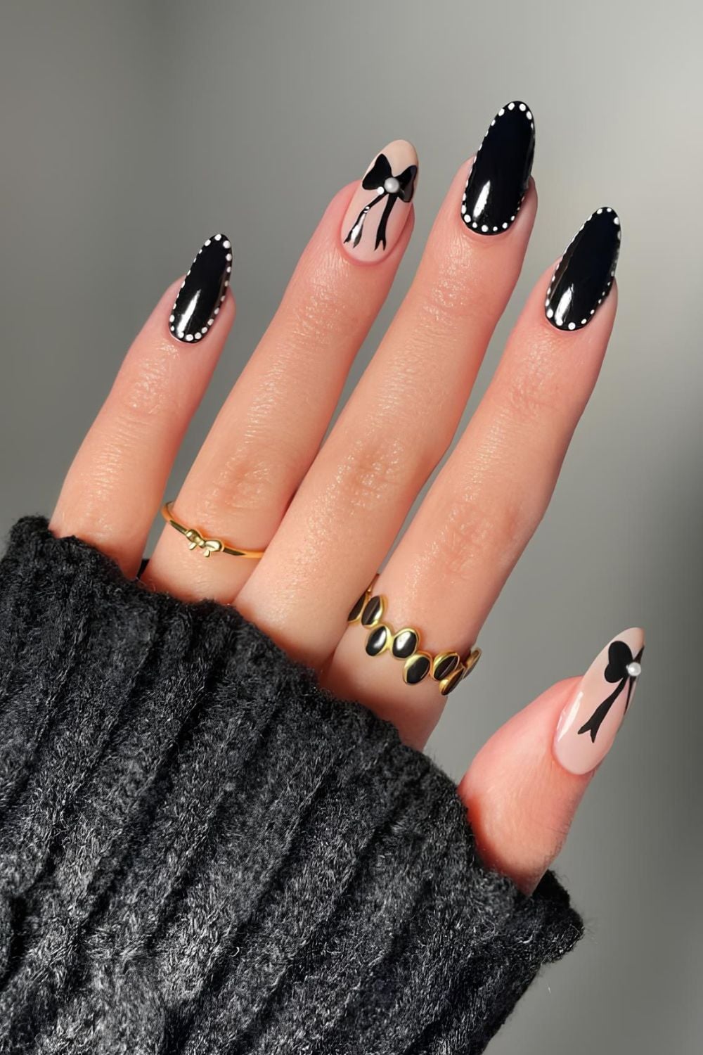 Black nails with white dot outlines and bow