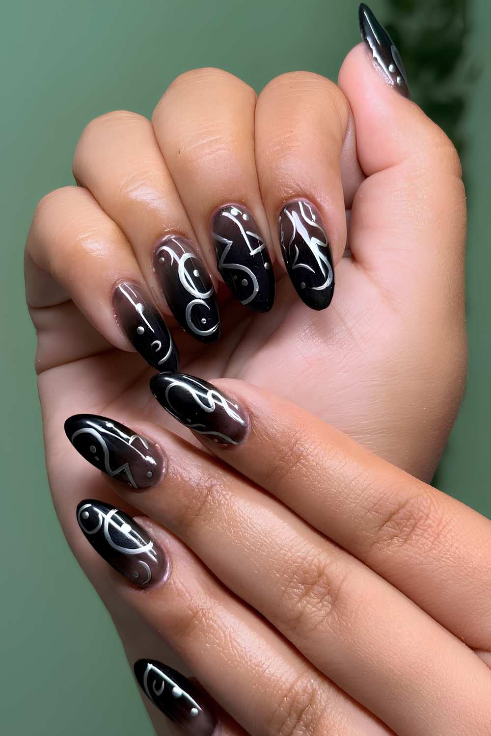 Black ombre nails with silver chrome swirls