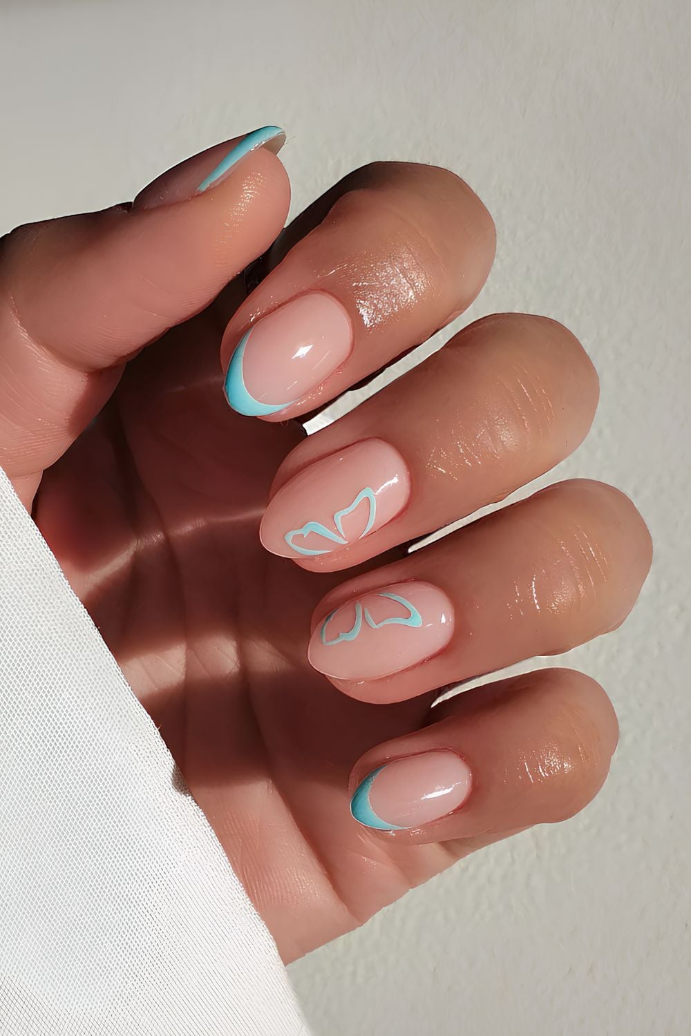 Blue French nails with butterfly wing art