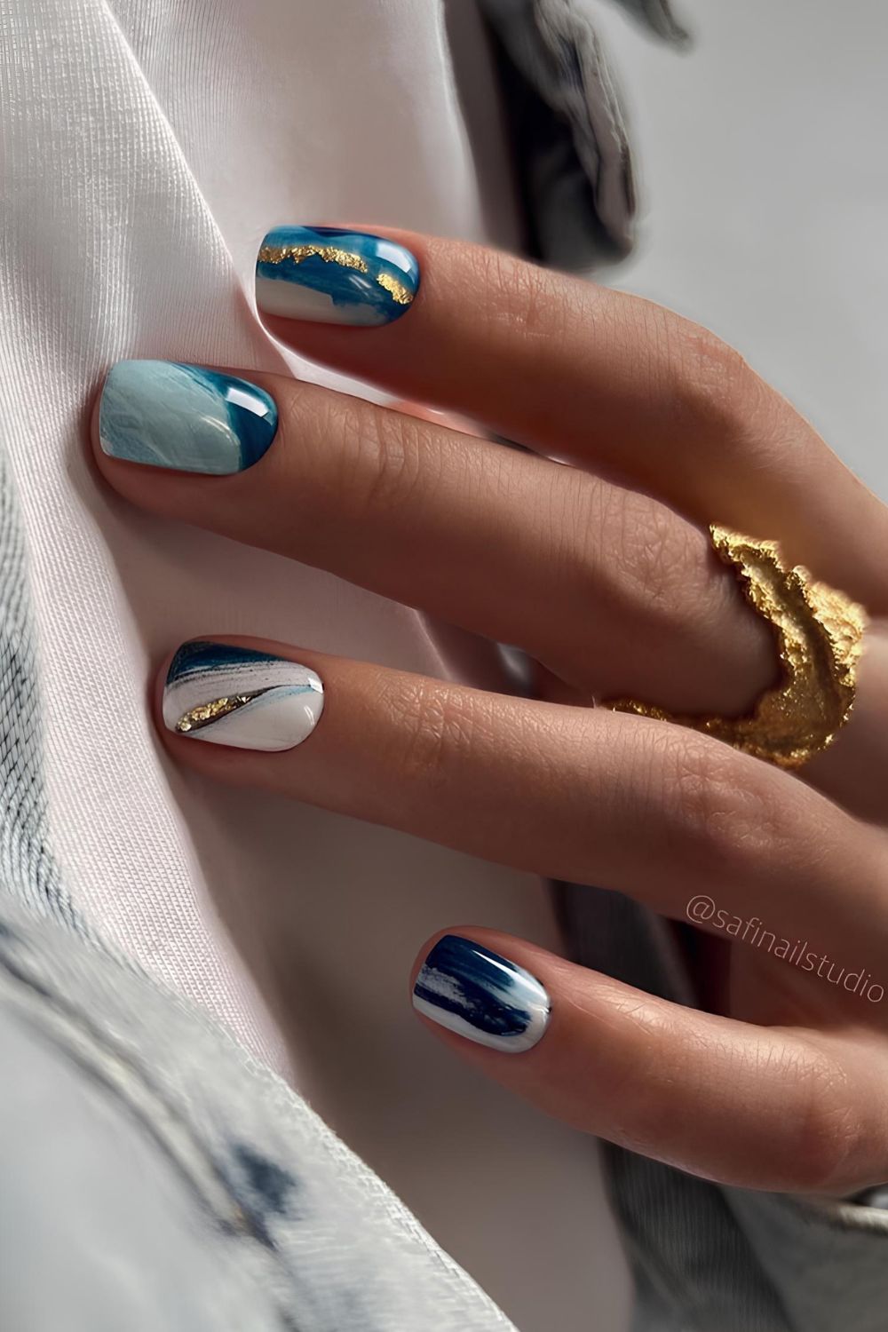 Blue and white marble nails with gold accents