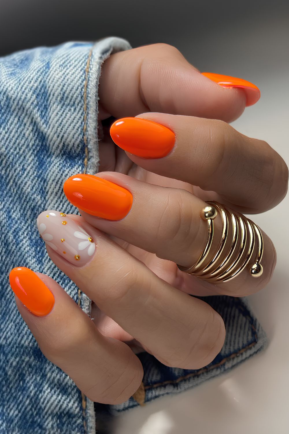 Bright orange mani with accent flowers