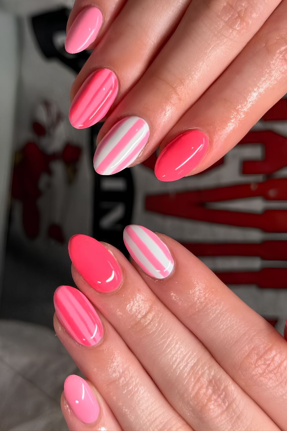 Bright pink skittle nails with stripe accents
