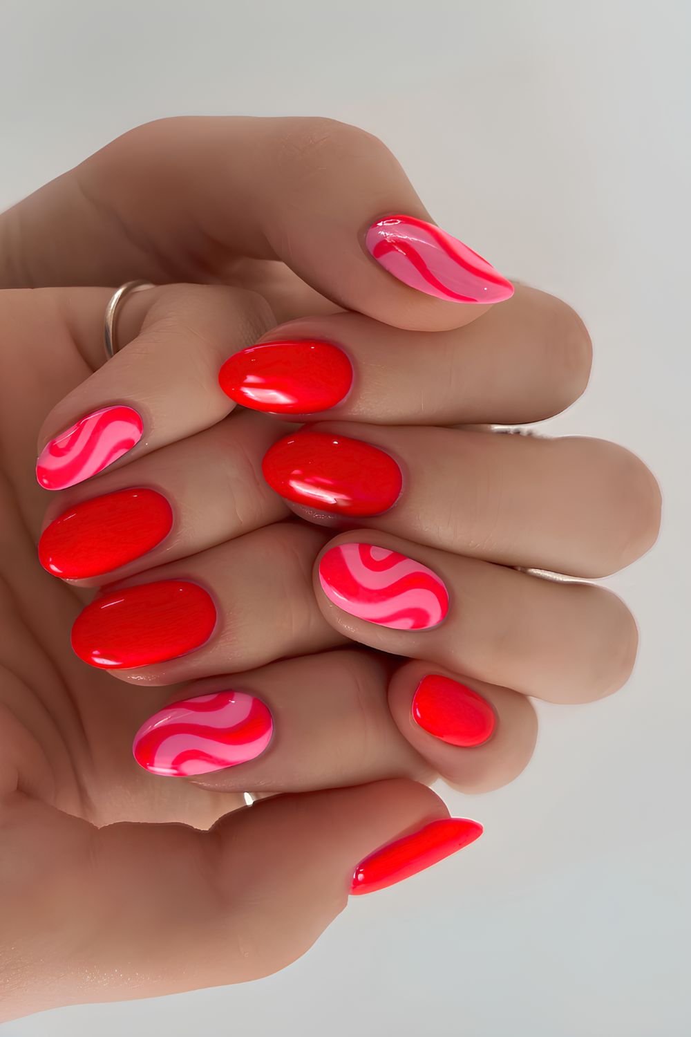 Bright red and pink nails with funky squiggles
