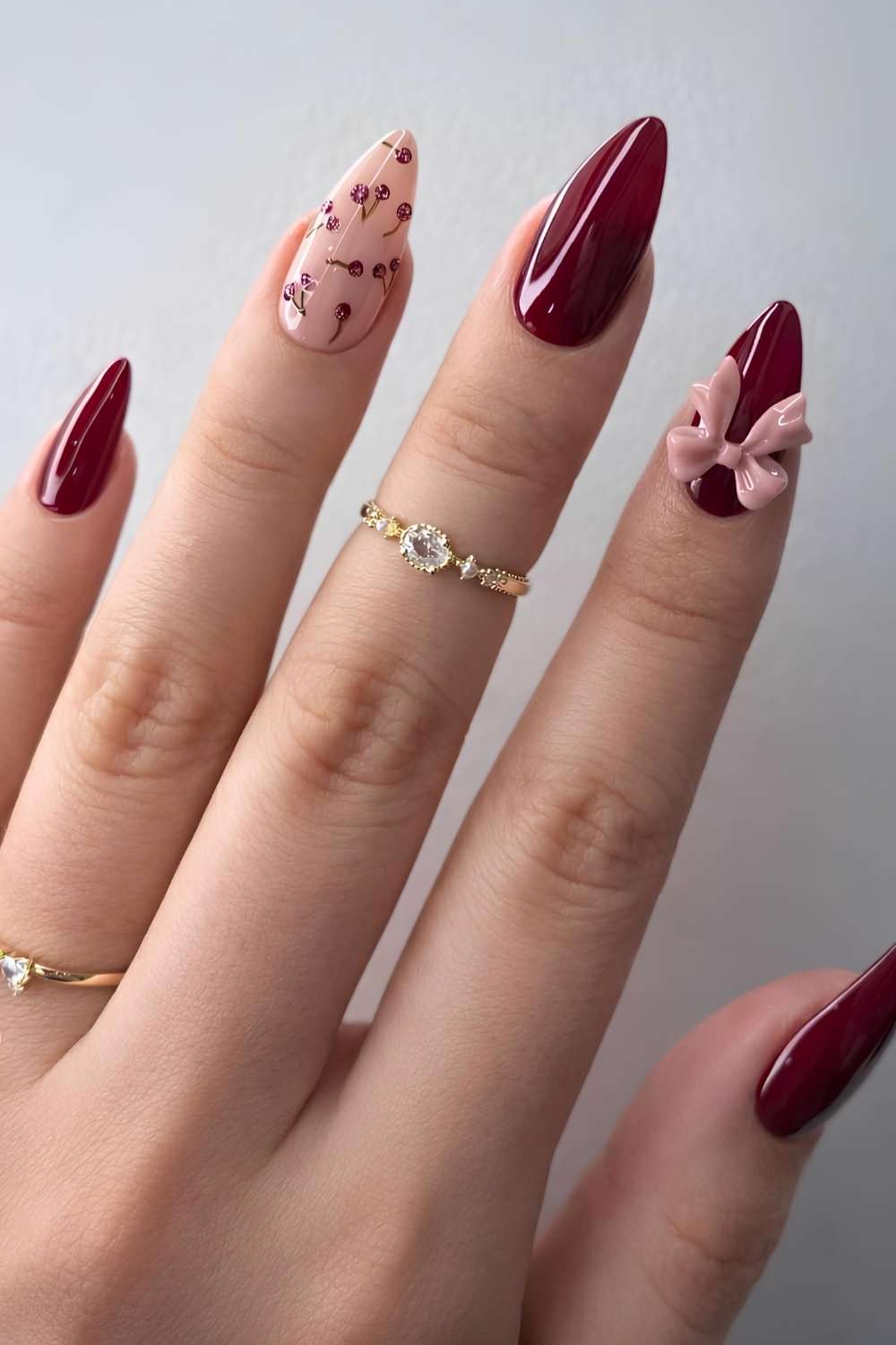 Burgundy and pink nails with cherry and bow art
