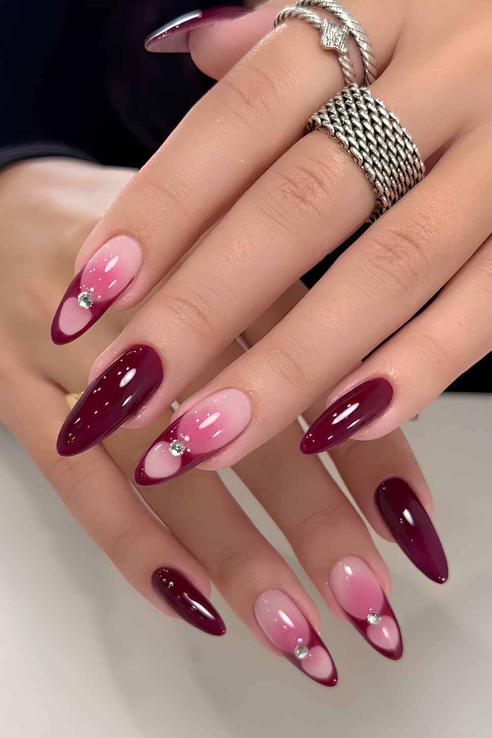 Burgundy and pink nails with rhinestone accent
