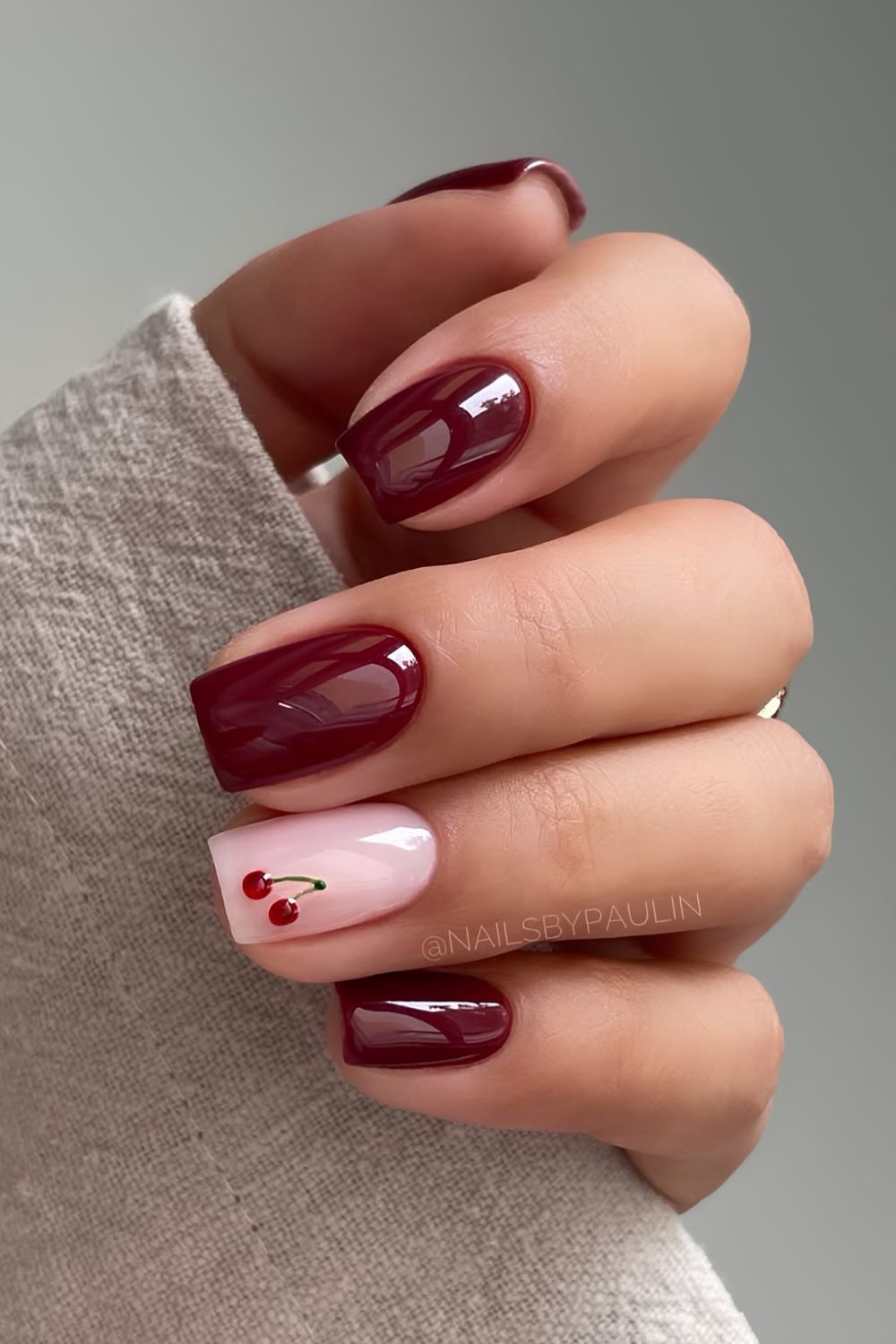 Burgundy manicure with accent cherry art