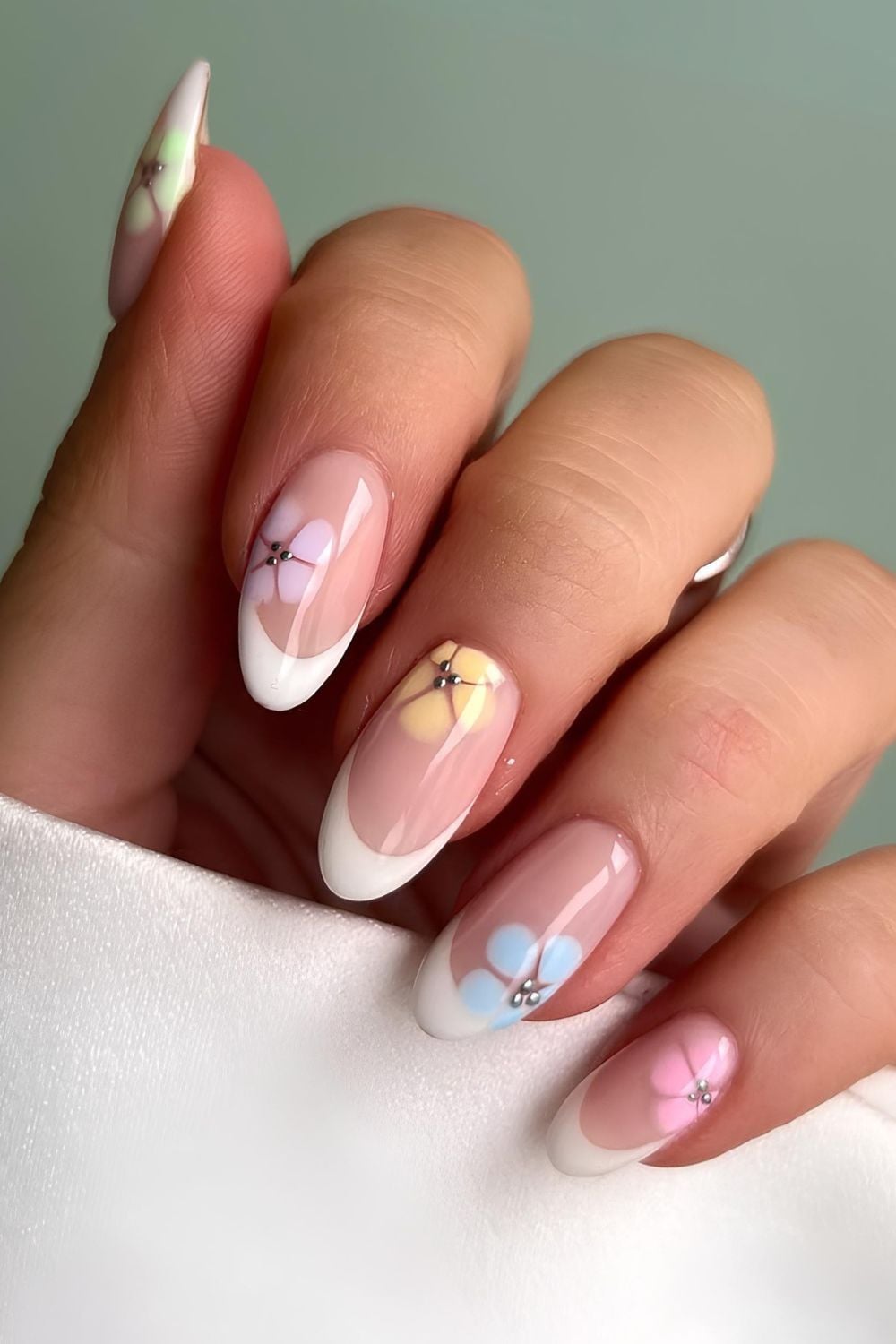 Classic French nails with pastel floral accents 