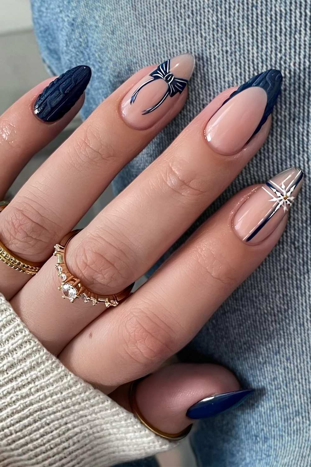 Dark blue nails with sweater patterns and snowflakes