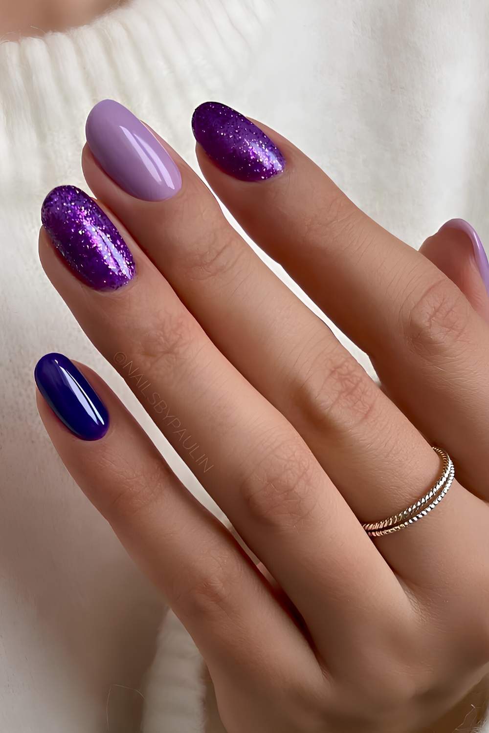 Dark purple nails with glitter accents