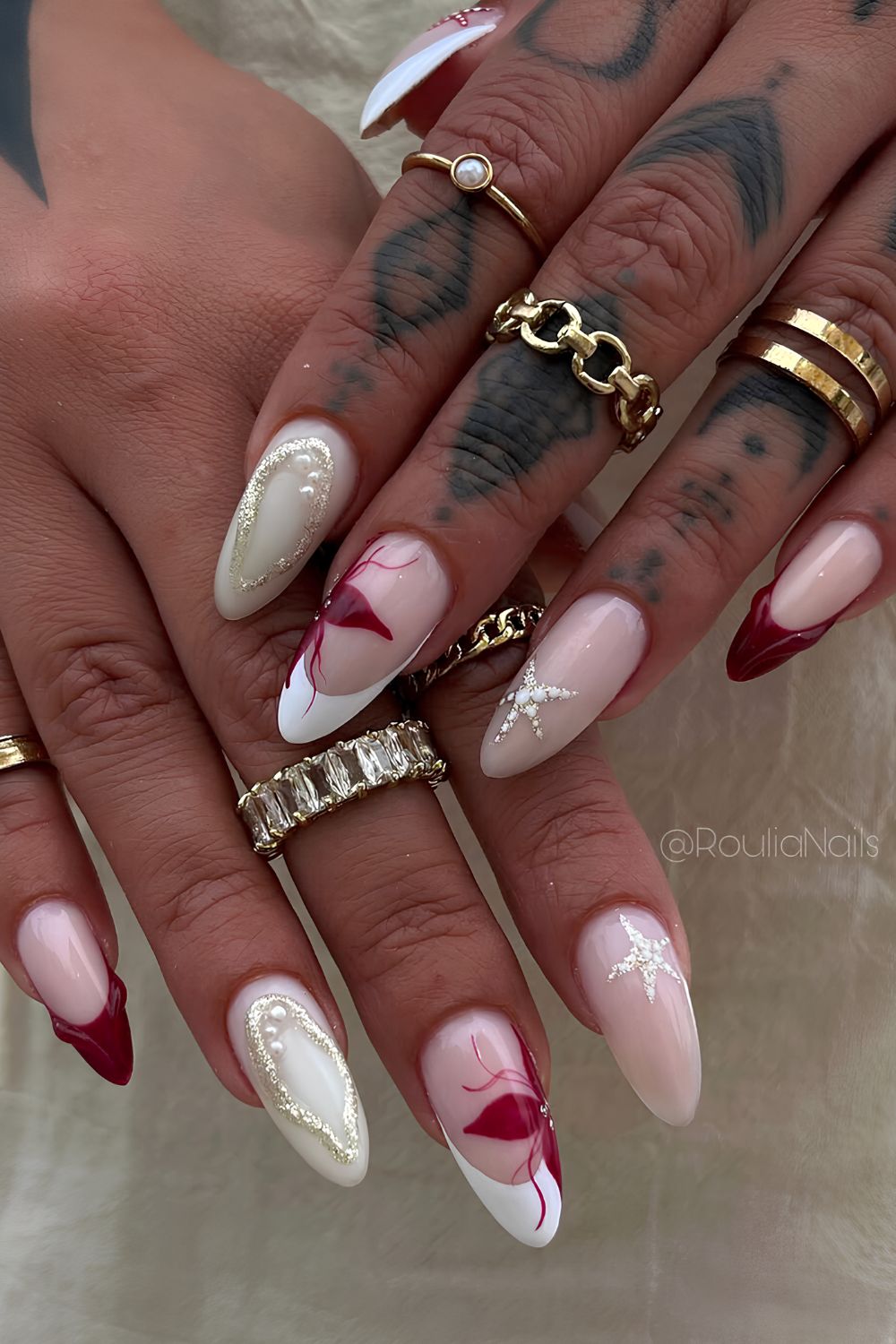 Dark red and white nails with gold starfish accents