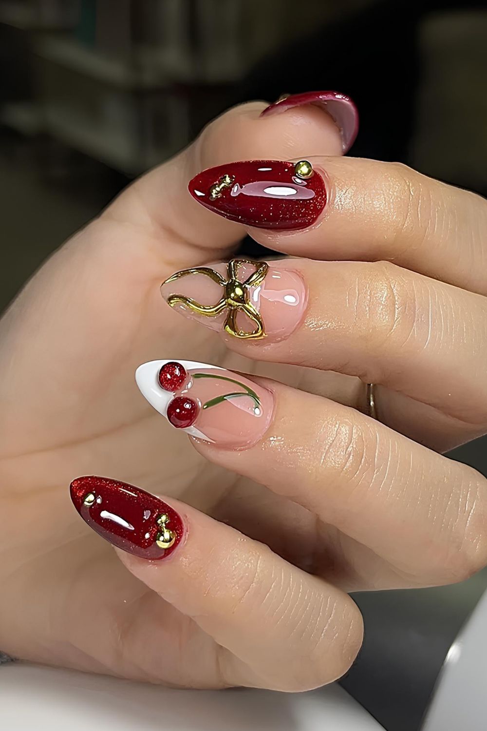 Dark red nails with cherry accents and gold details