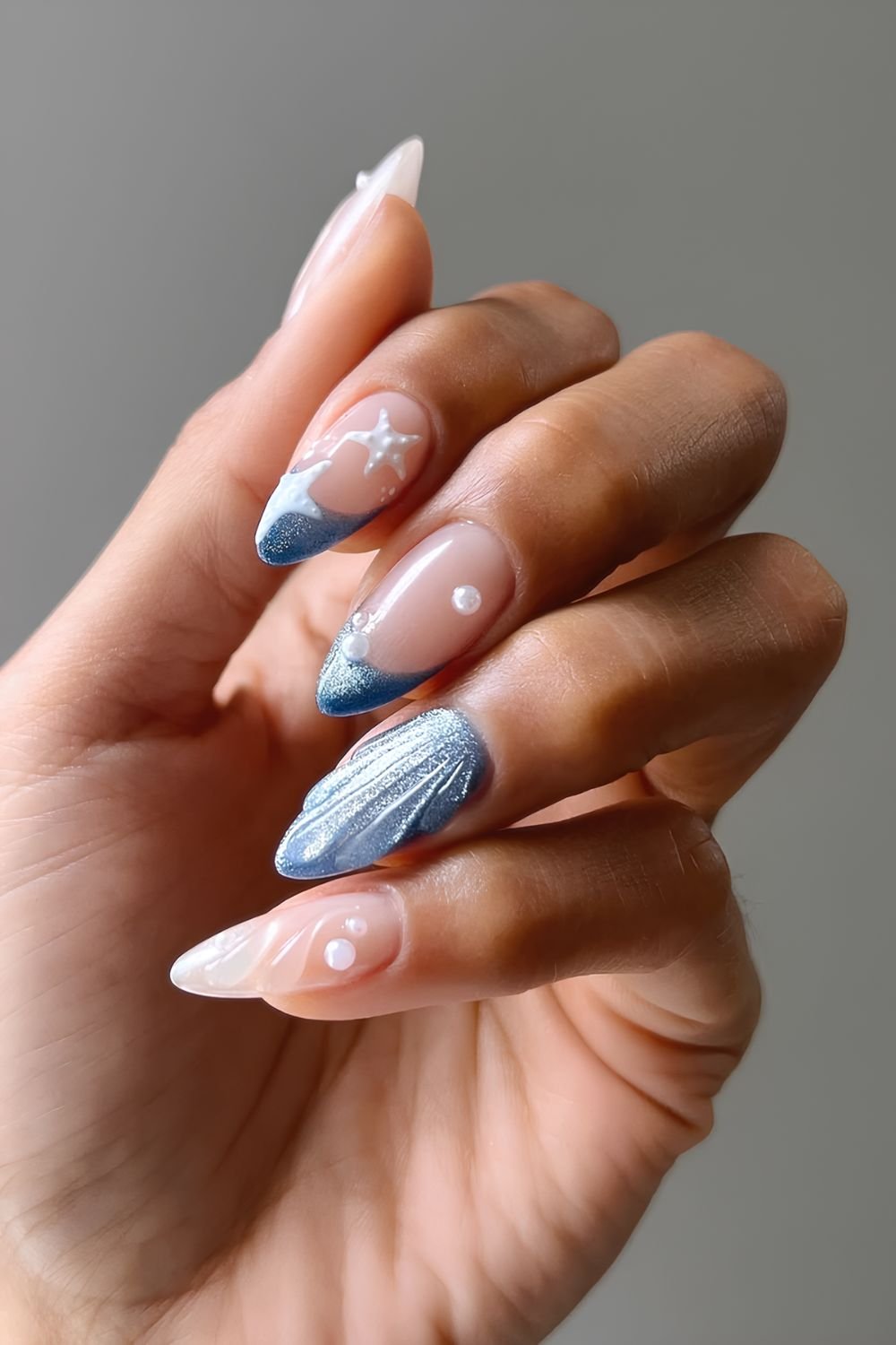 Deeep ocean blue cat eye nails and sheer white textured nails with pearl and white starfish accents