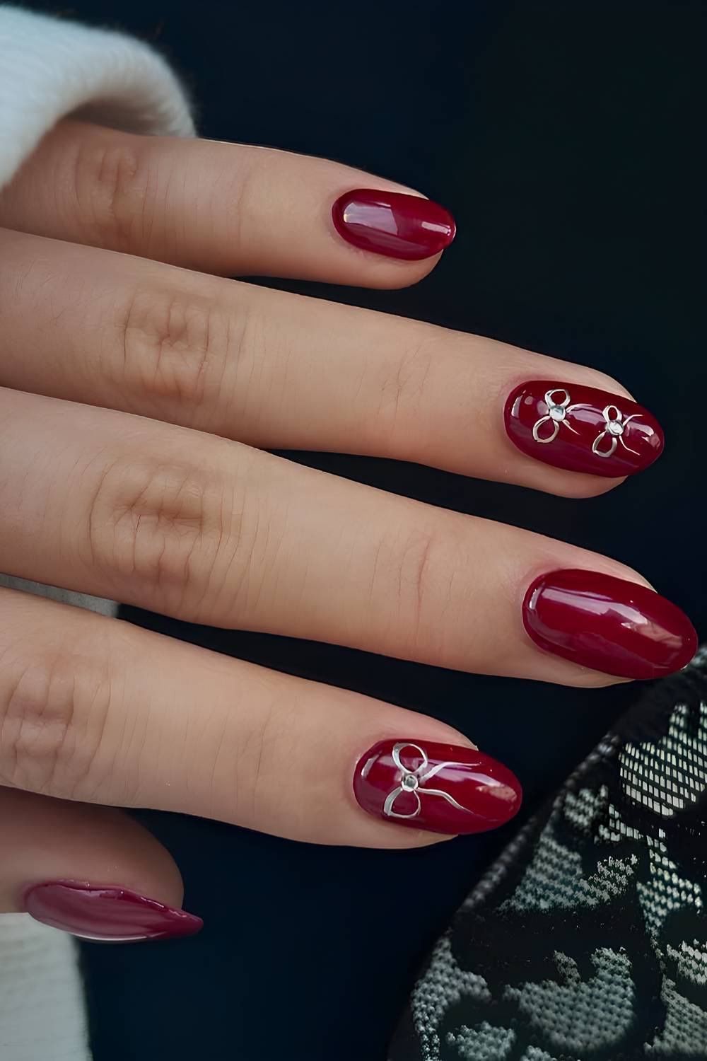 Deep red nails with silver bow art