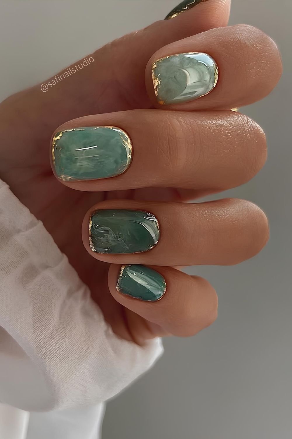 Elegant jade green marble nails with gold accents