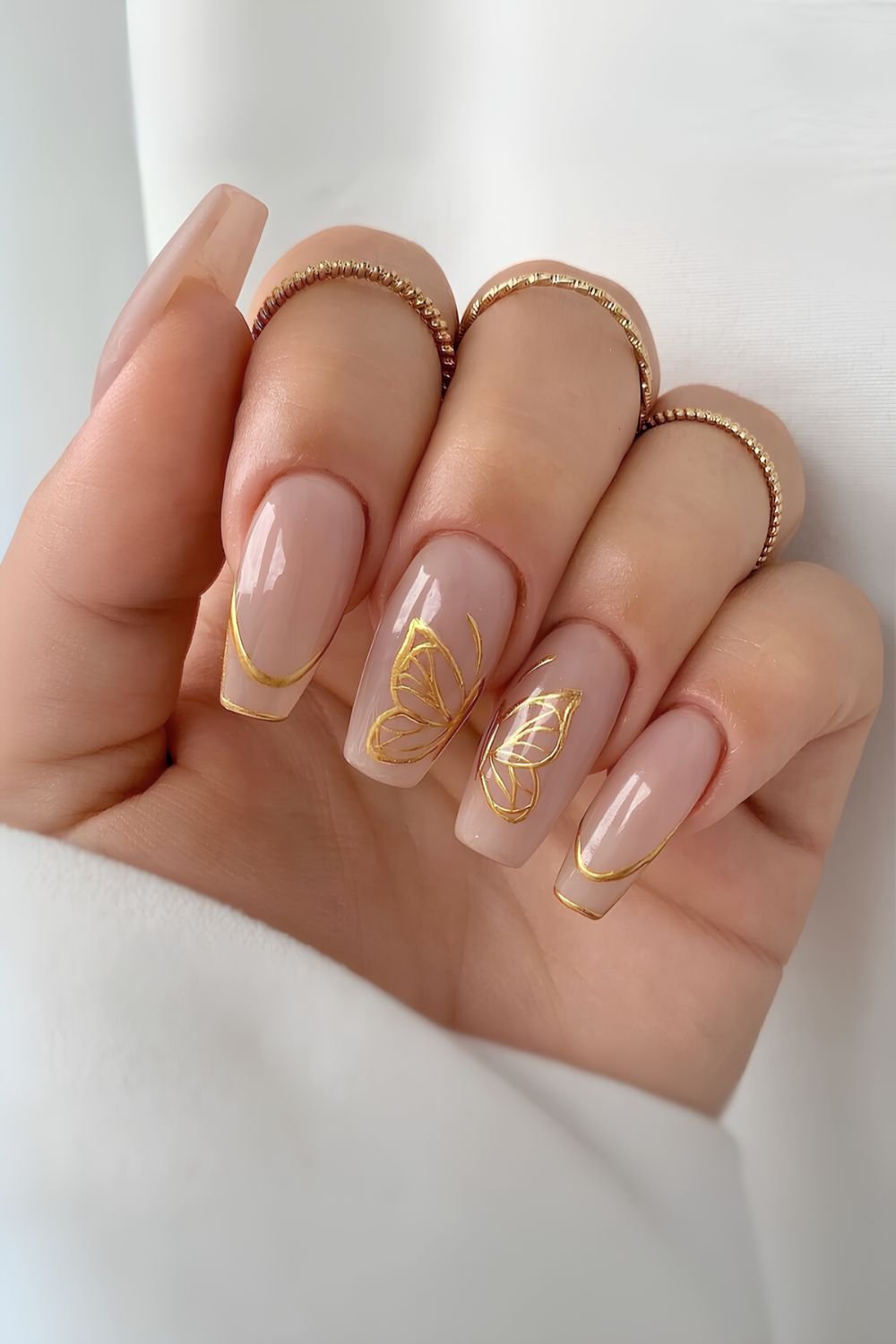 Gold French tip outline nails with butterflies