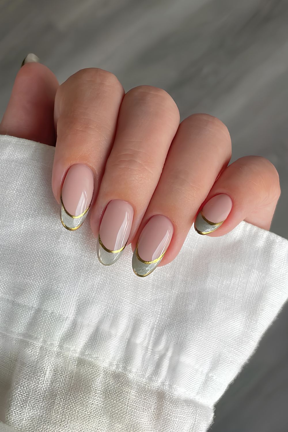Gold chrome double French tip nails with green cat eye effect