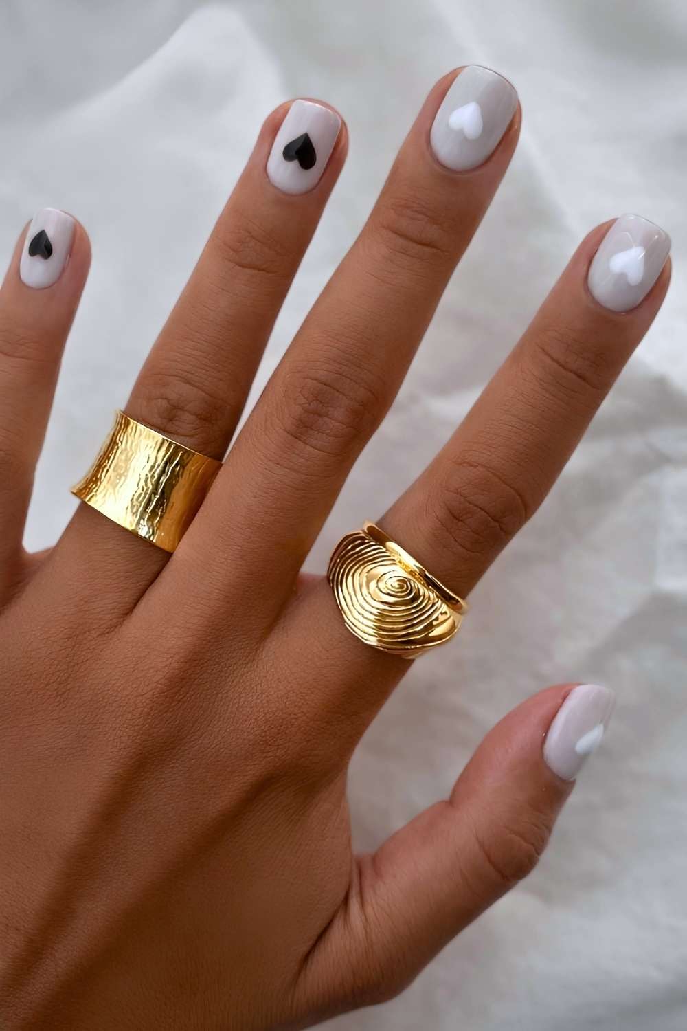 Gray nails with white and black hearts