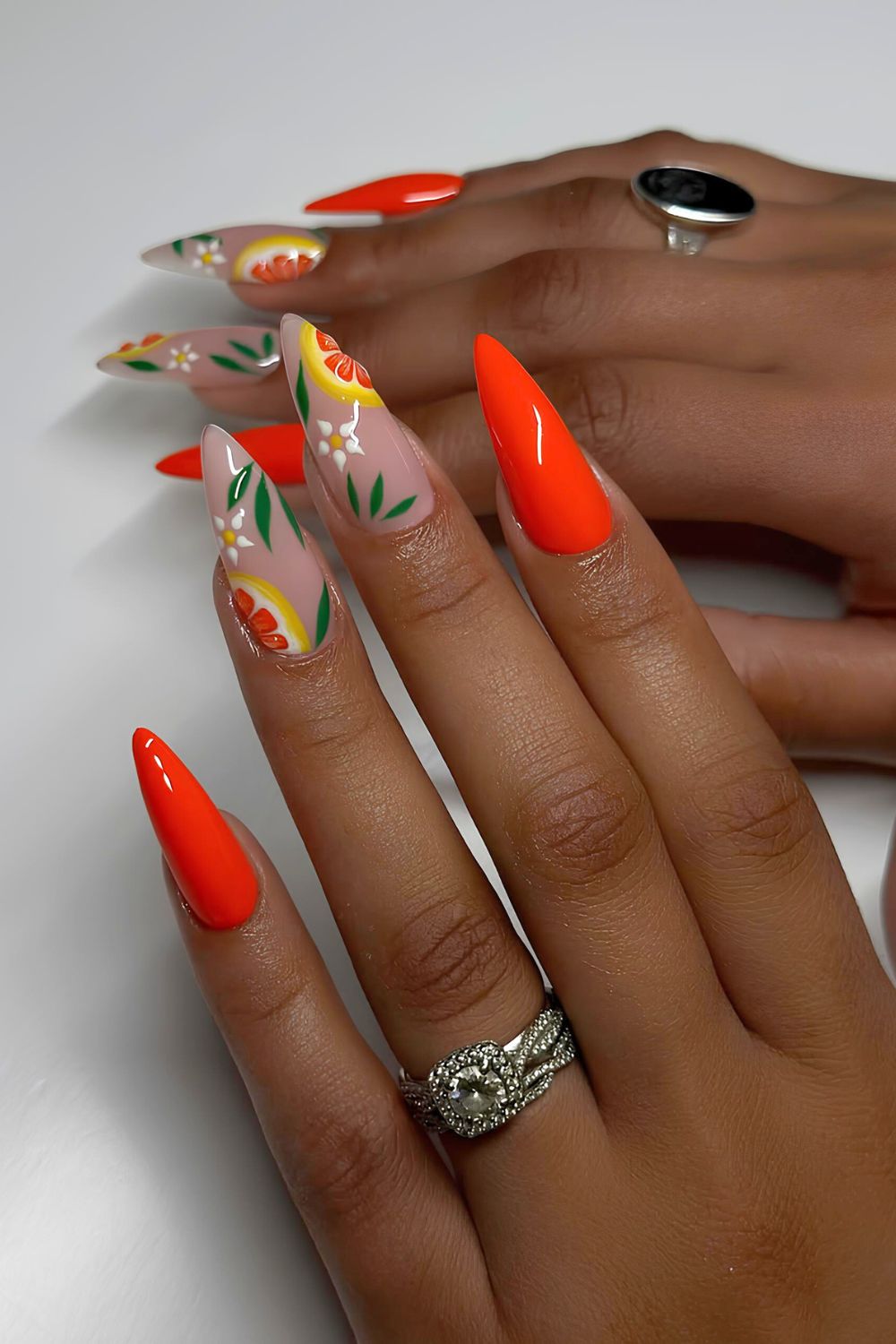 Hot orange nails with fruity and floral accents