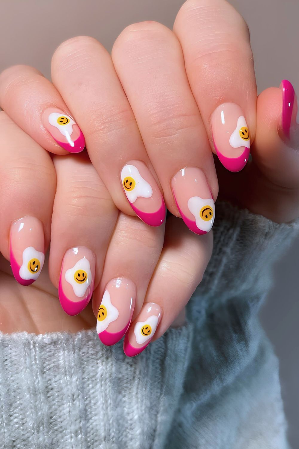 Hot pink French manicure with smiley sunny side up egg design