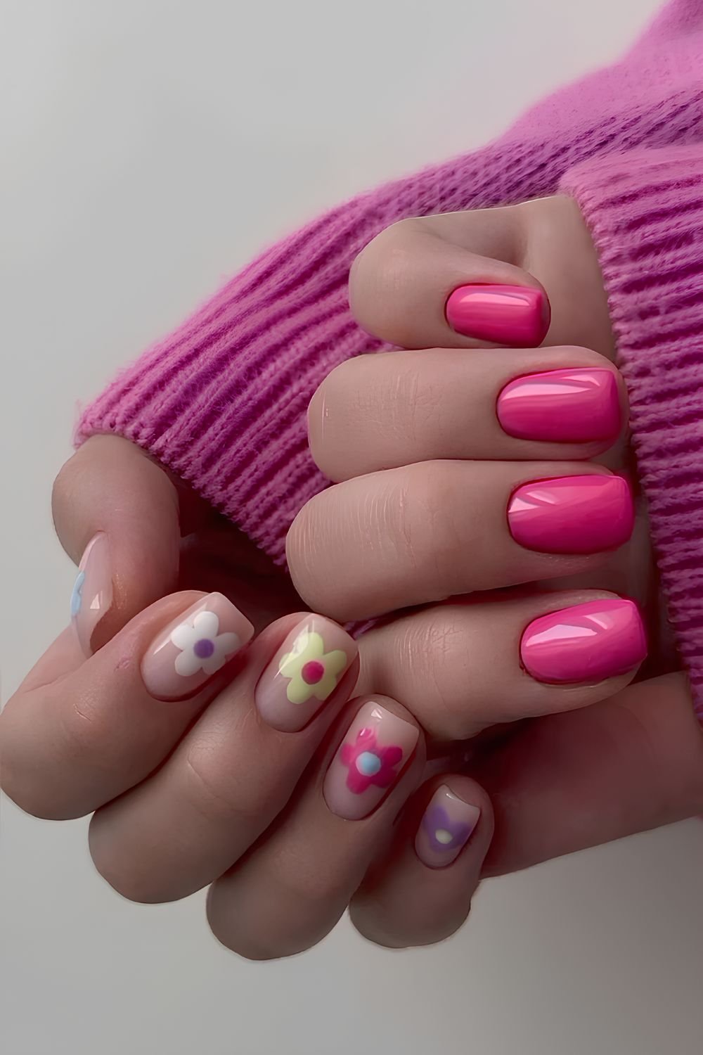 Hot pink nails with colorful flower accents
