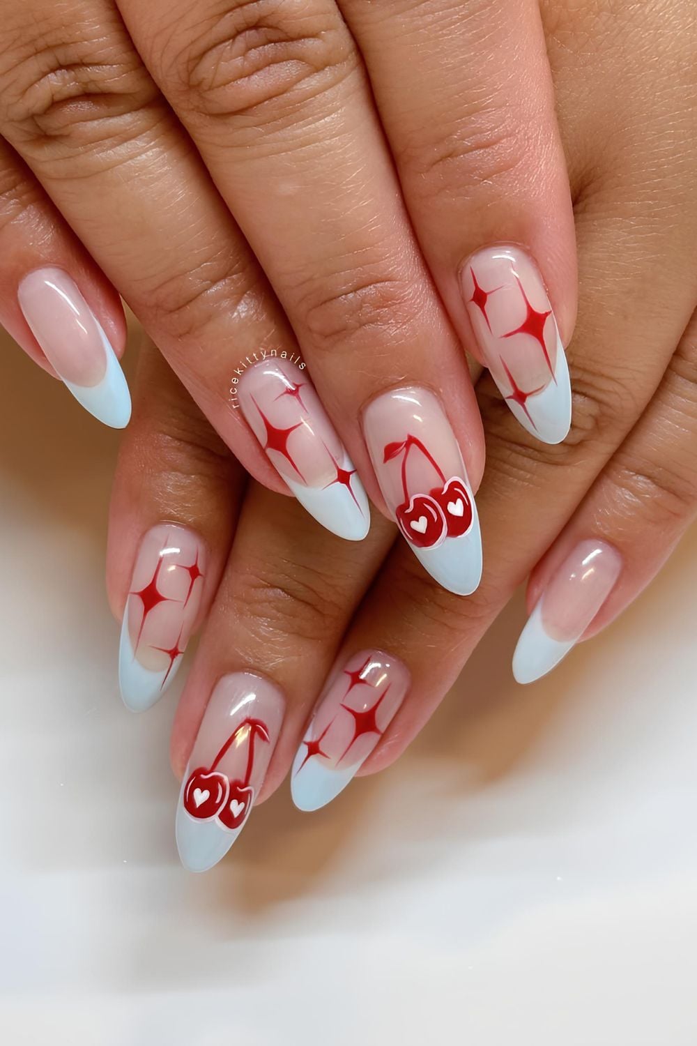 Light blue French nails with red stars and cherries