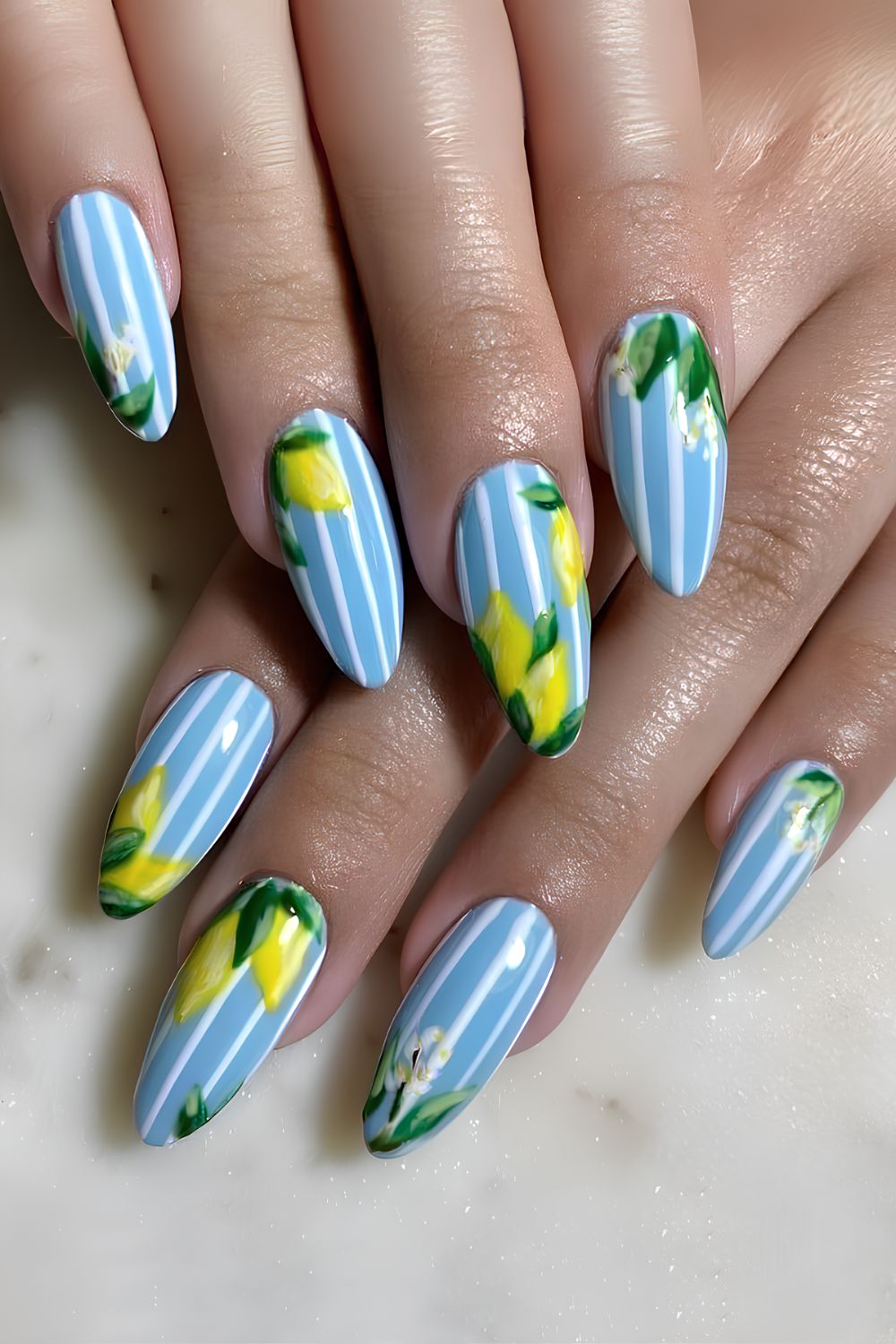 Light blue nails with white stripes and lemon and floral accents