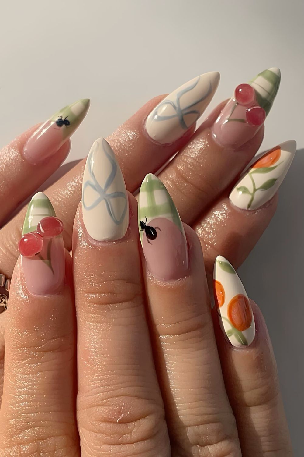 Light green and white nails with cherries, bows and fruity accents