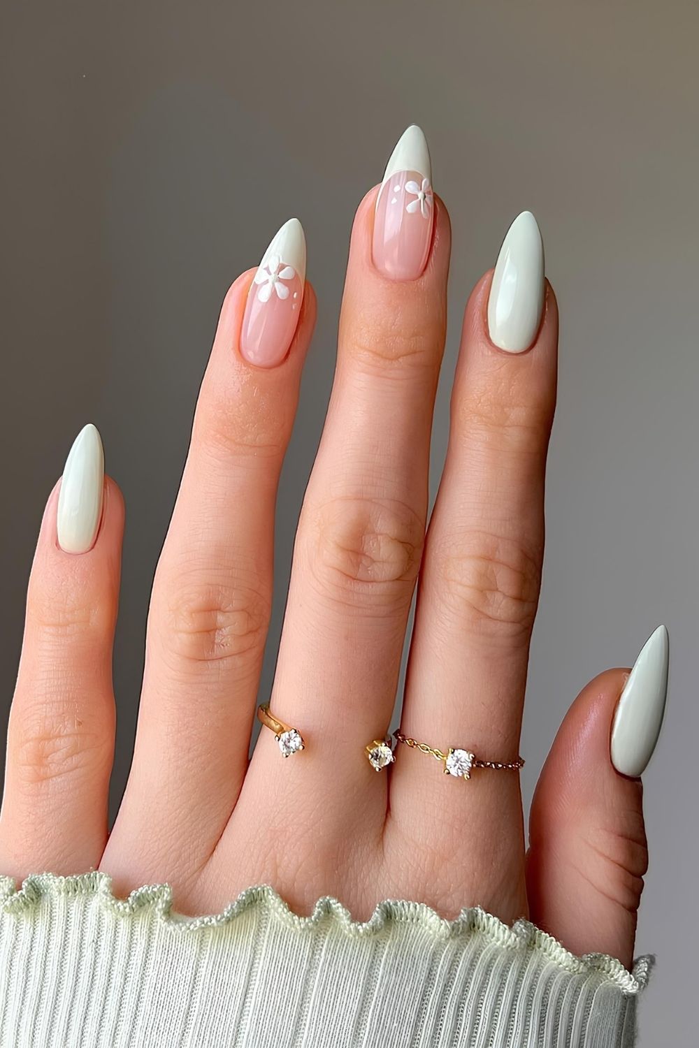 Light green pastel nails with white floral and French tip accents