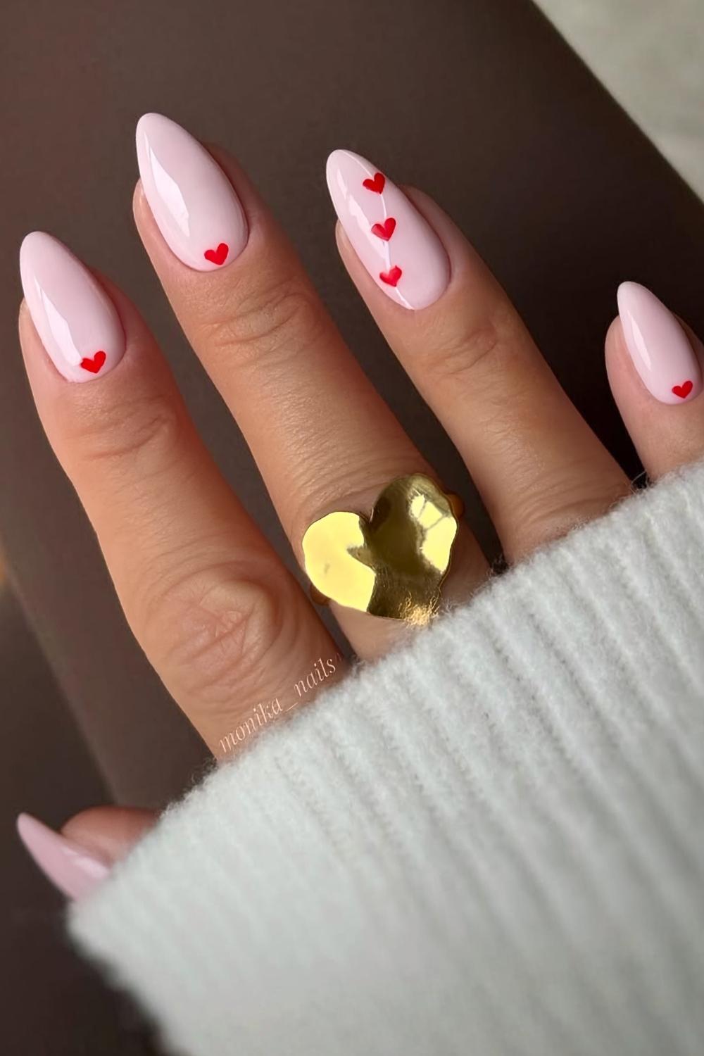 Light pink manicure with accent red hearts