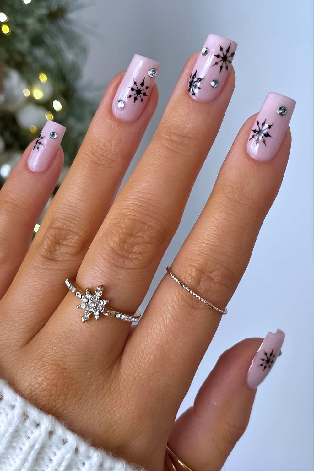 Light pink nails with black snowflakes