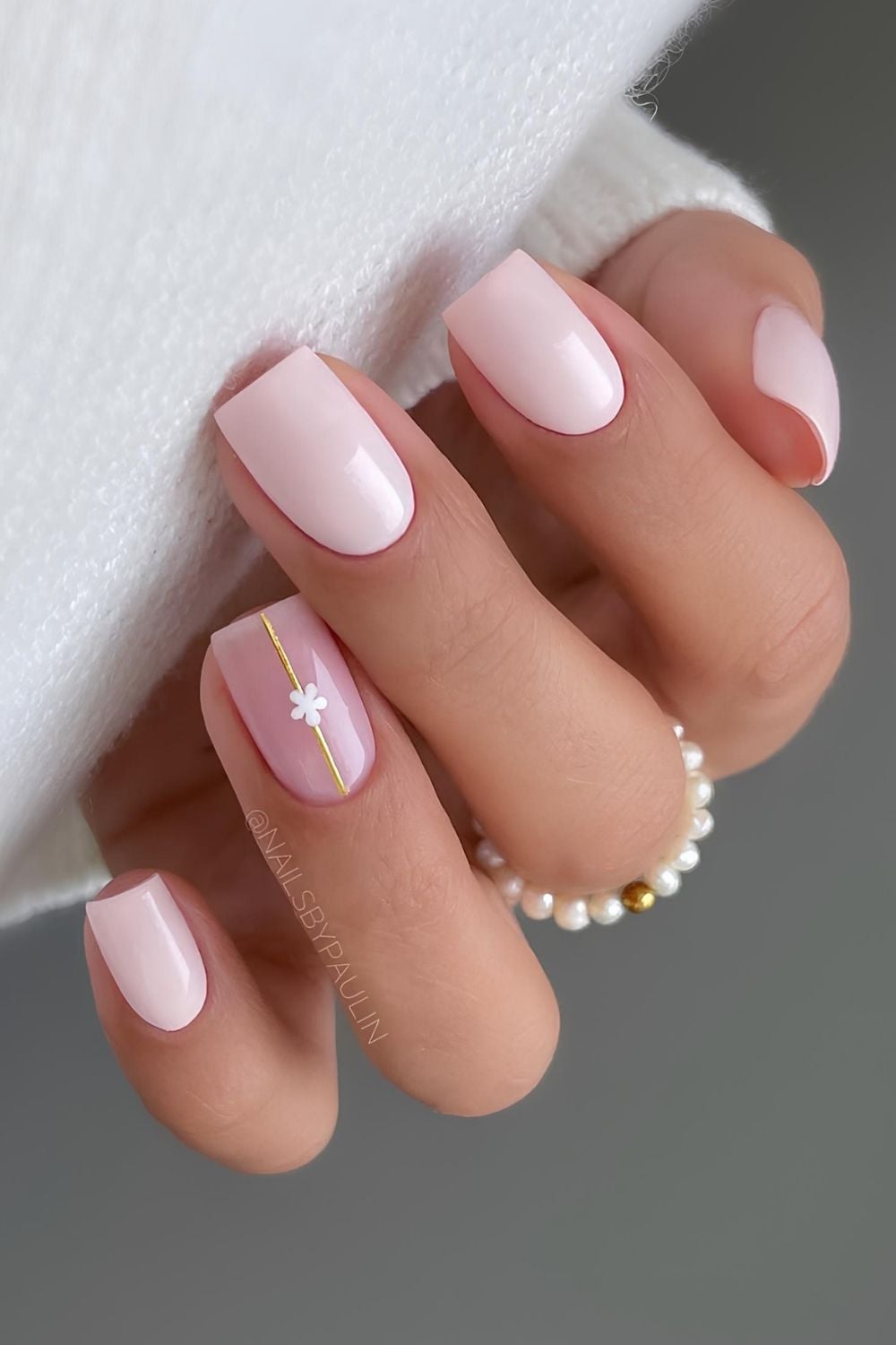 Light pink nails with gold line and flower
