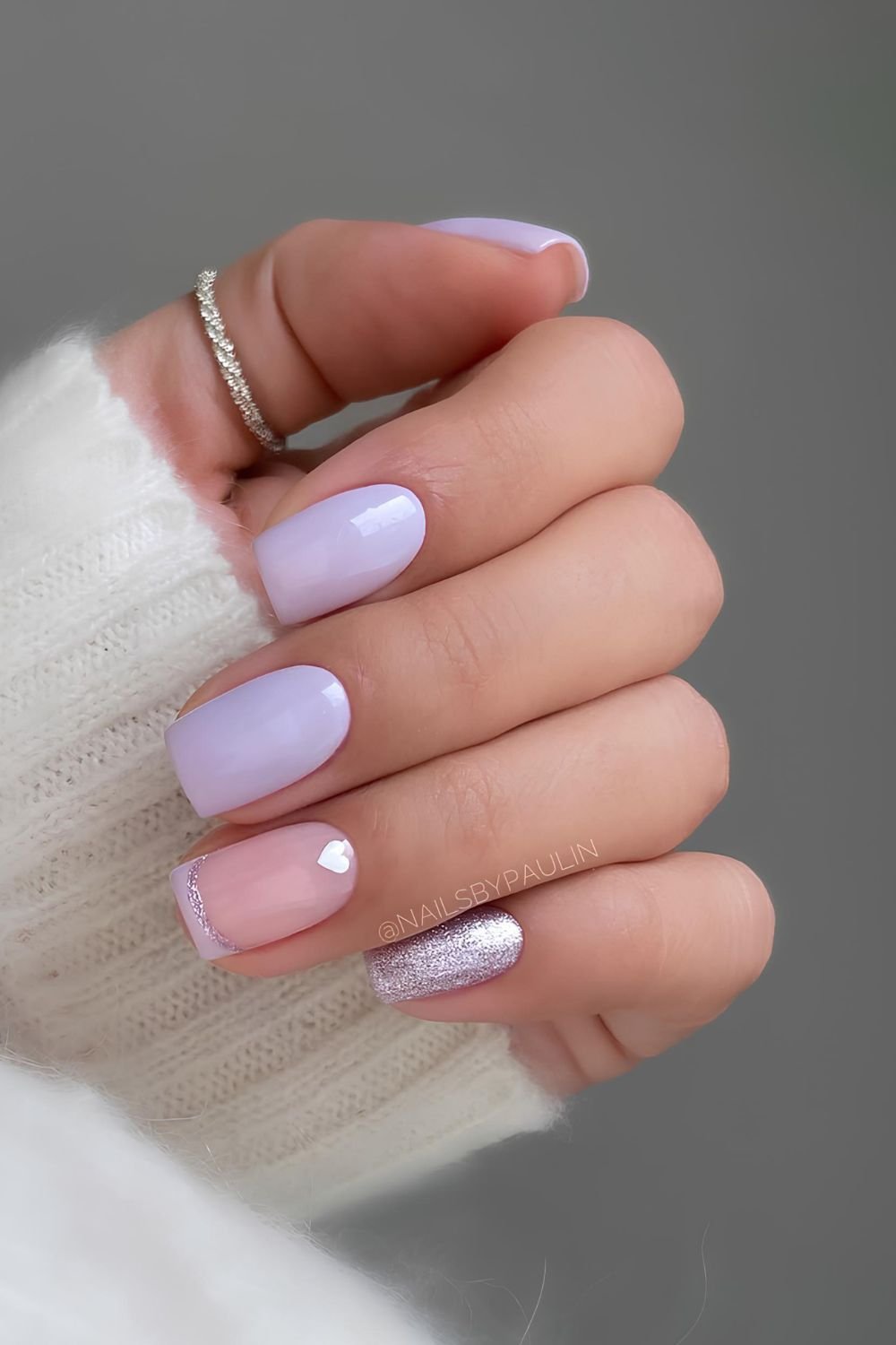 Light purple nails with glitter accents and tiny heart