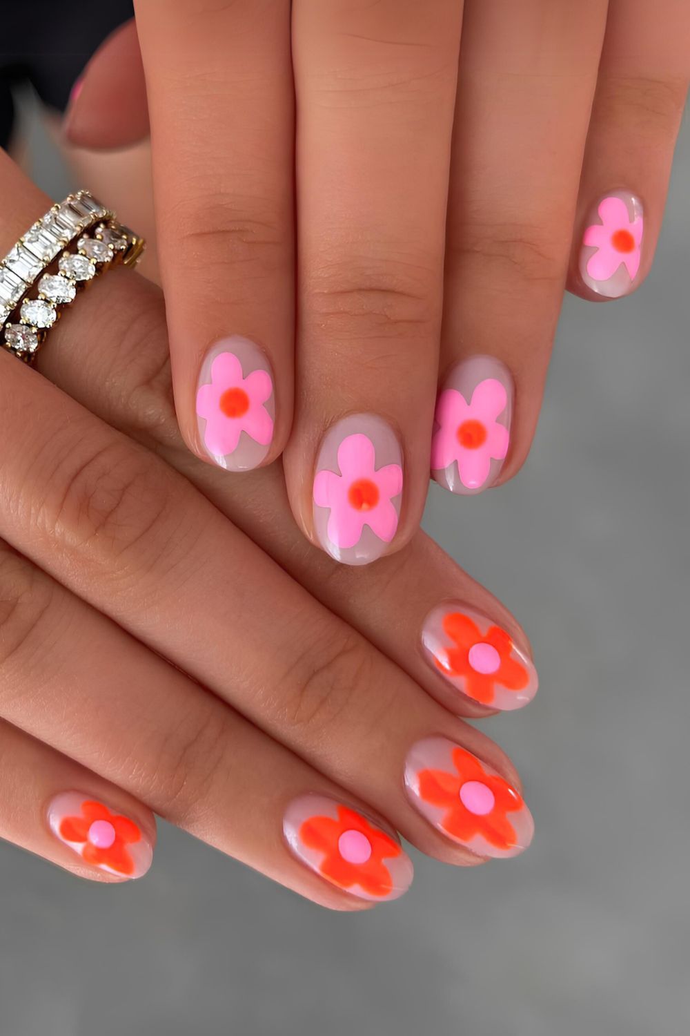 Milky nails with alternating pink and orange flowers