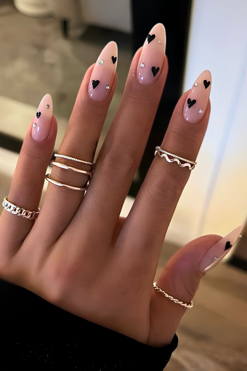 Milky nails with black hearts and rhinestones accent