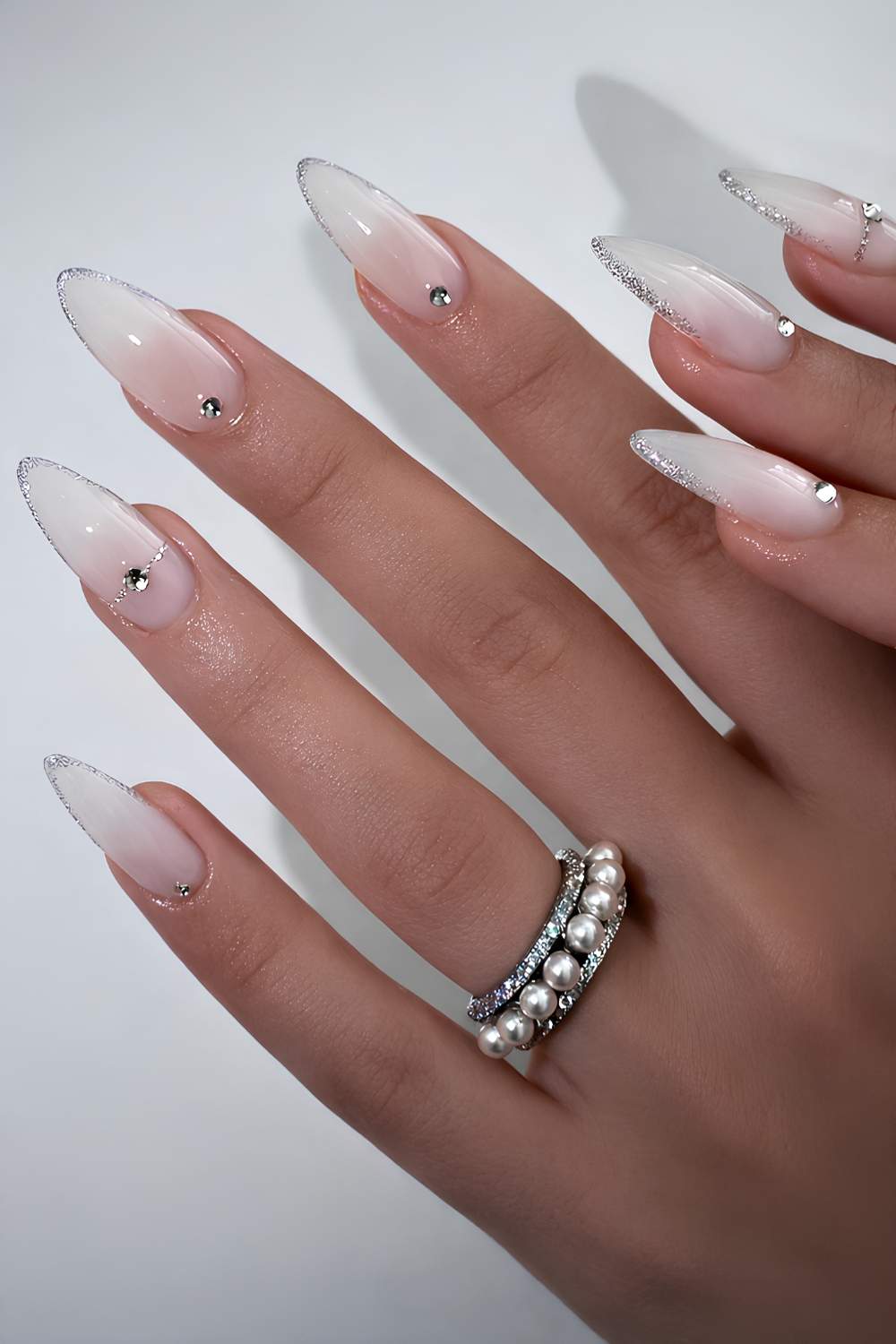 Milky nails with glitter French tips and rhinestones