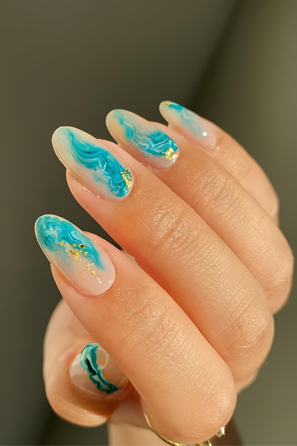 Milky nails with light blue marble swirls and gold foil accents
