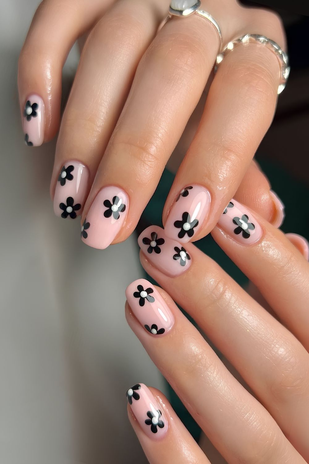 Milky pink nails with black flowers