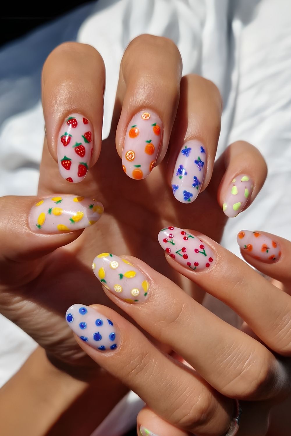 Milky white mani with different fruit art on each nail