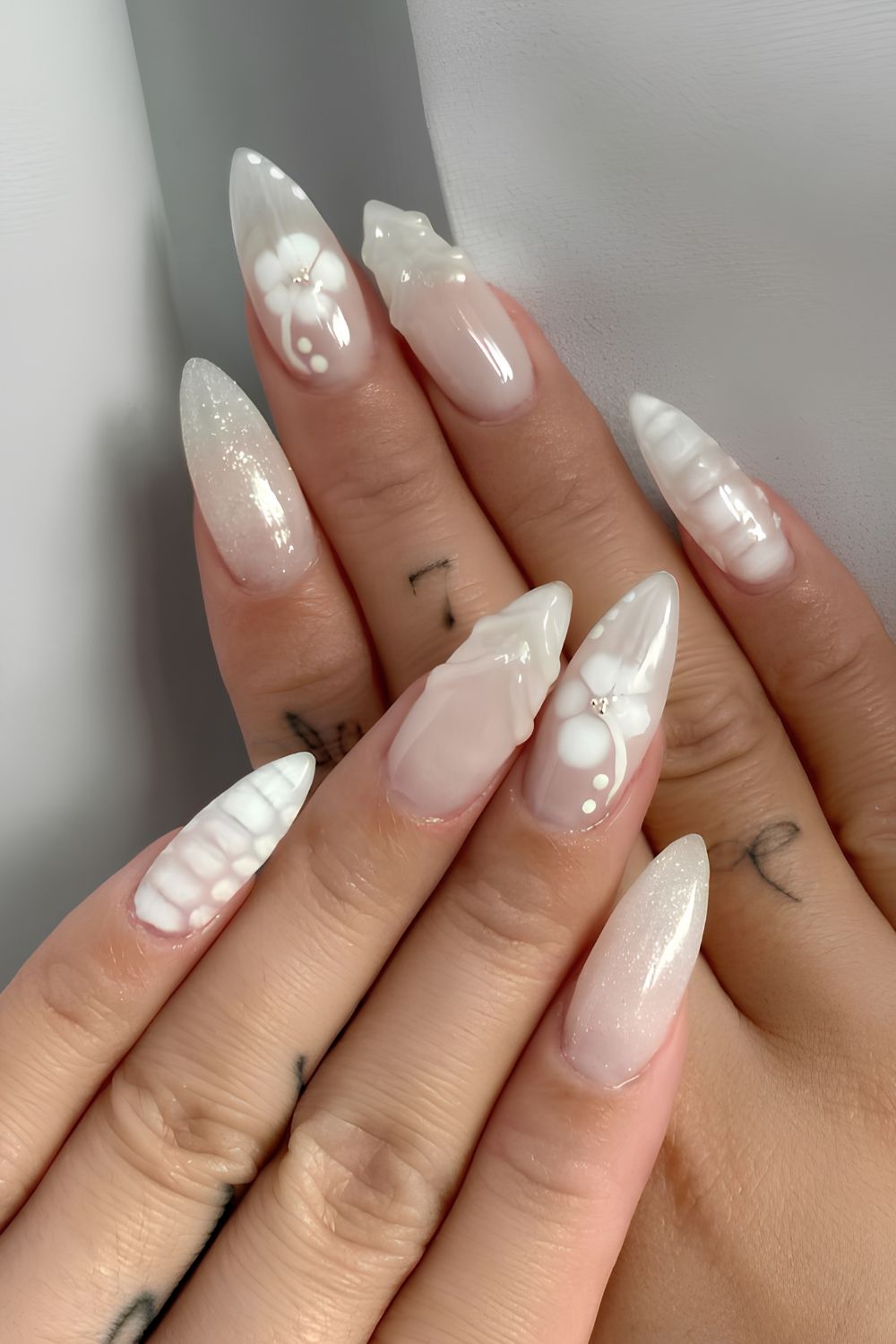 Milky white nails with blooming flowers and textured accents