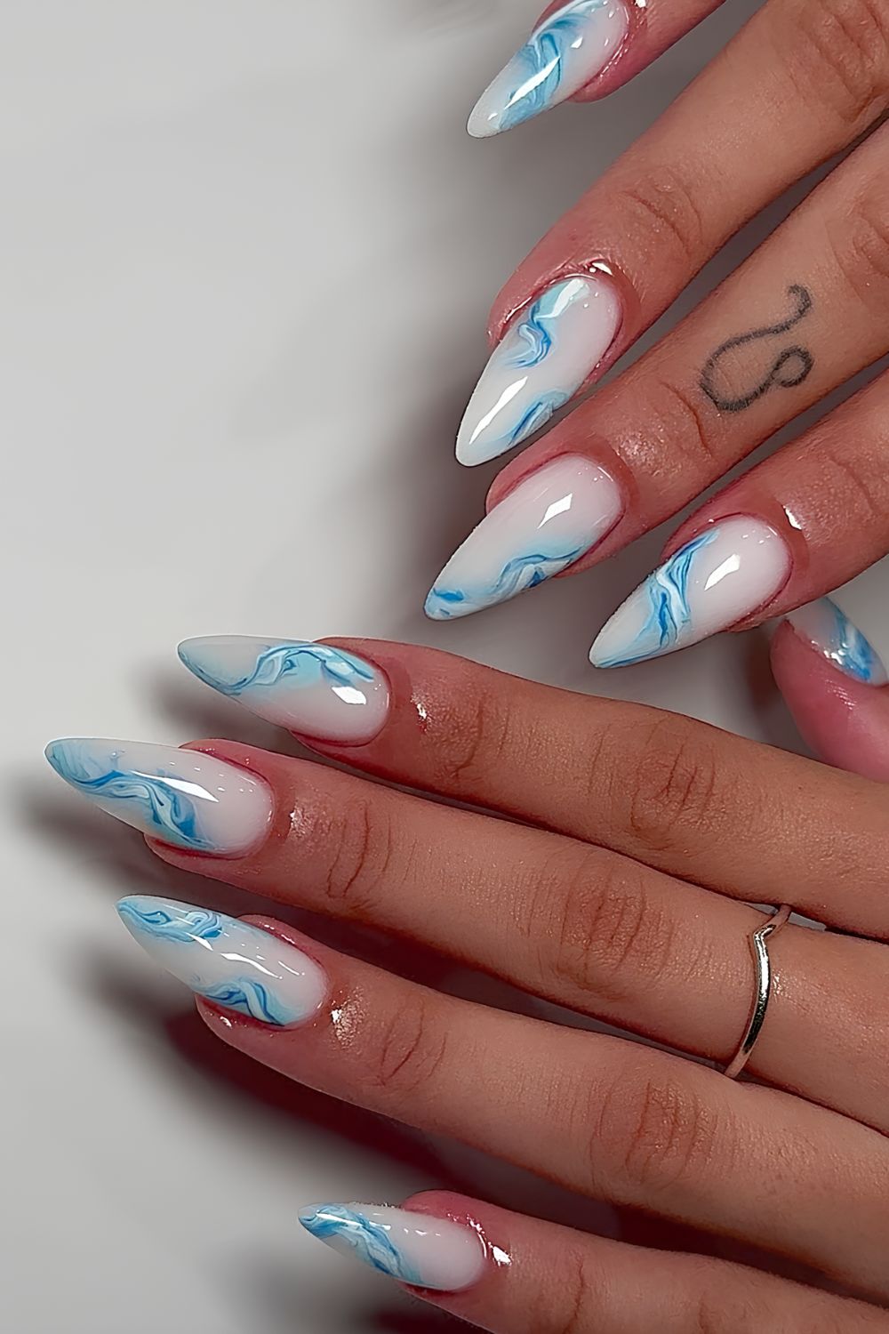 Milky white nails with blue and white marble swirls