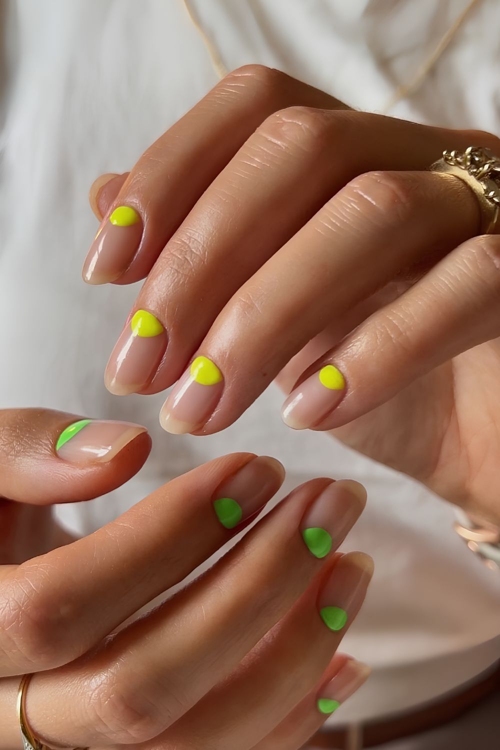 Natural nails with neon green and yellow dots on cuticles