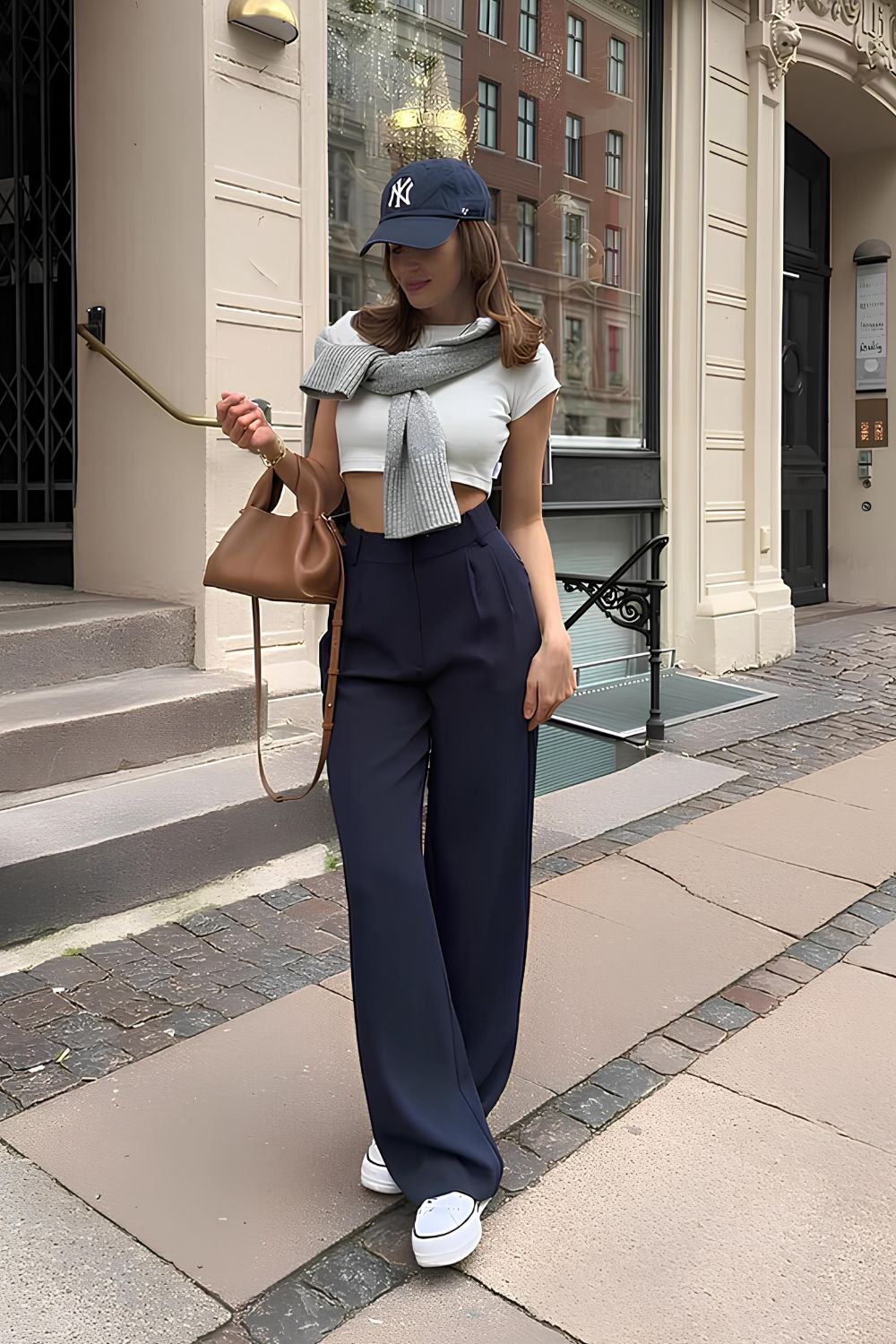Navy blue wide leg pants with cropped white tee and grey sweater on shoulders
