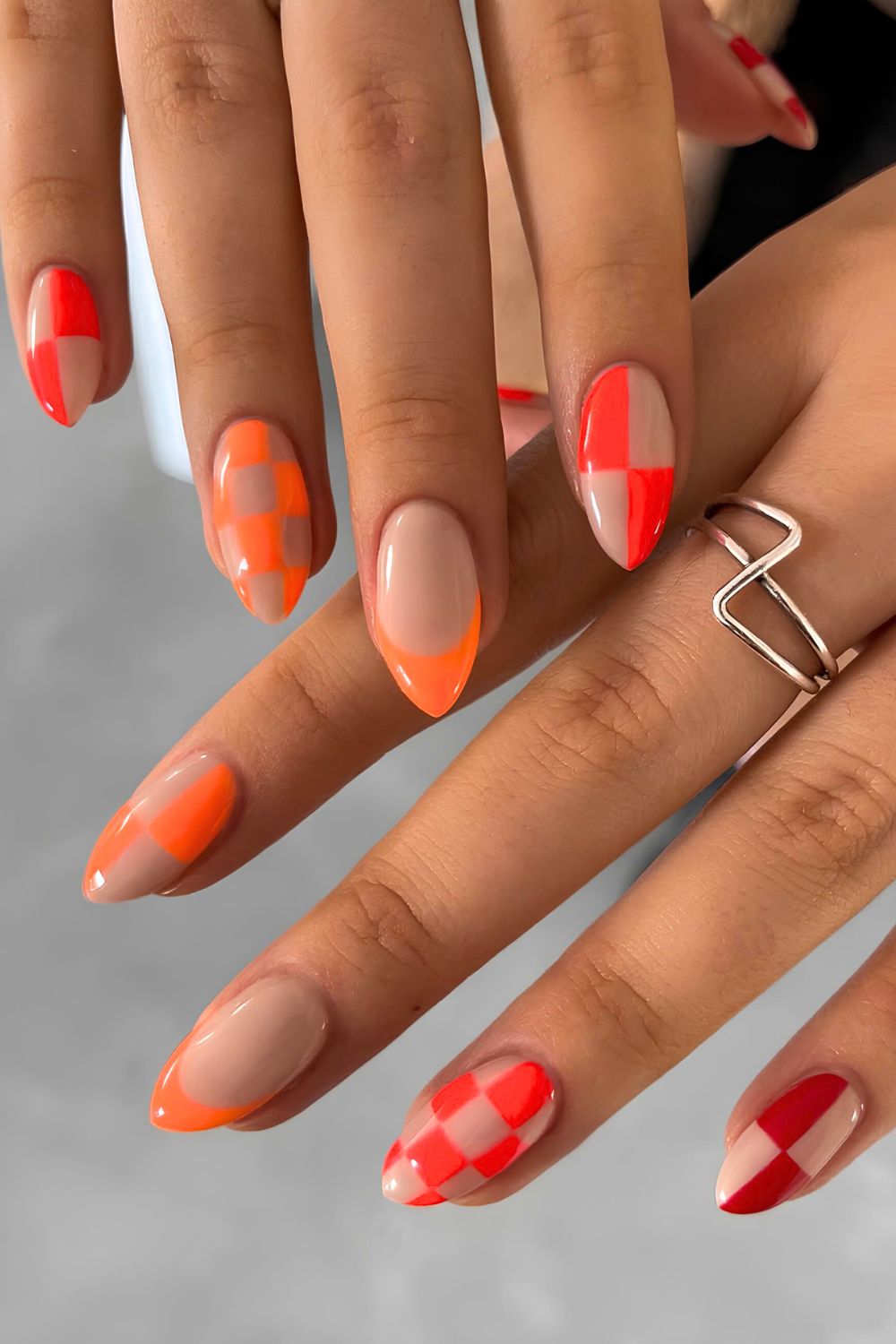 Neon red and orange French mani with checkerboard accents