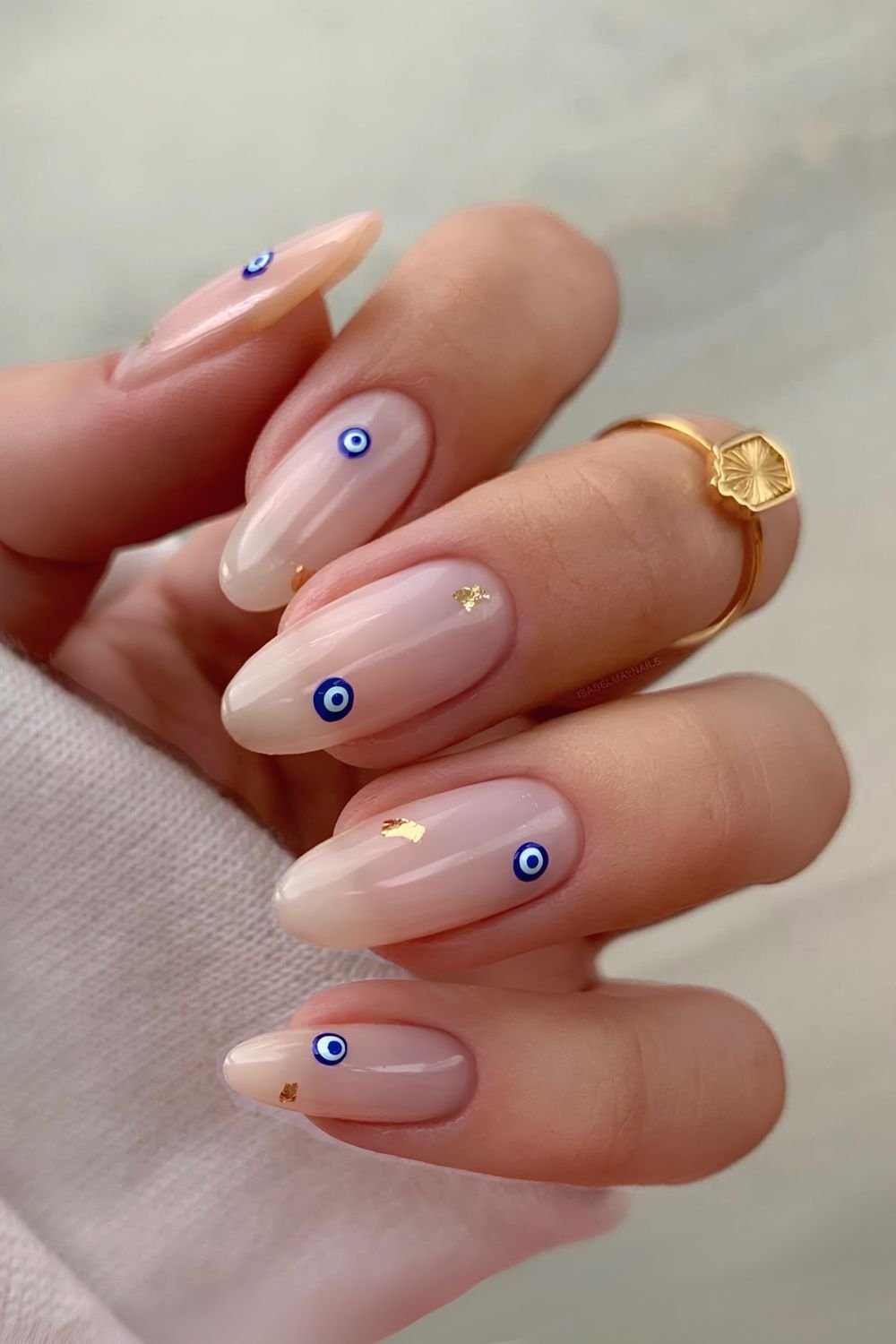 Neutral evil eye nails with gold foil flecks