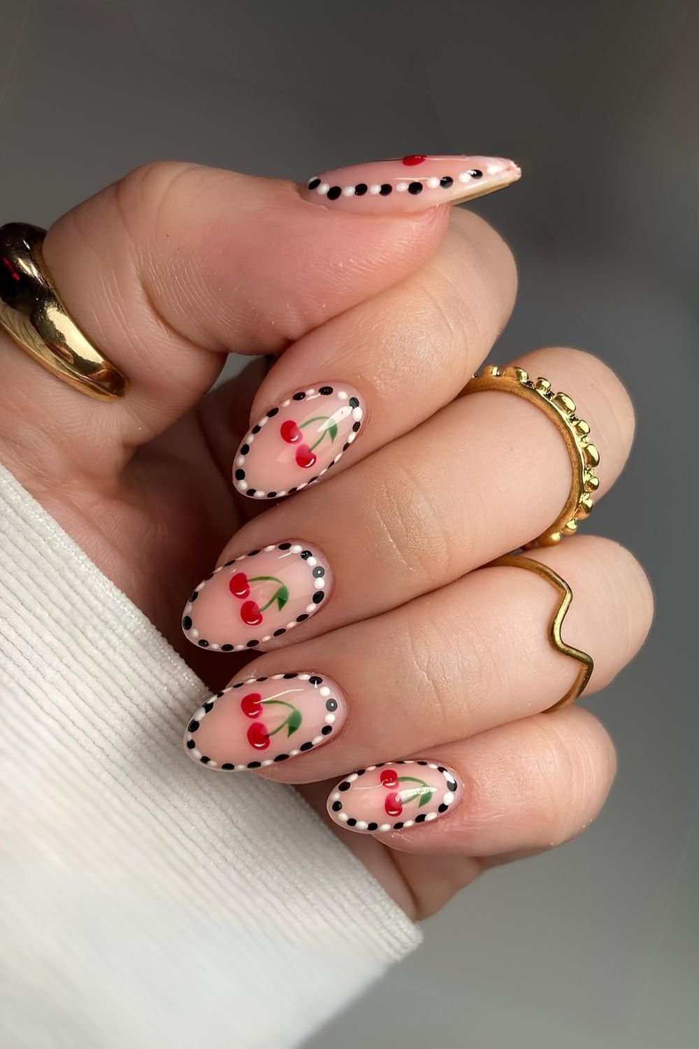 Neutral nails with dot and cherry accents