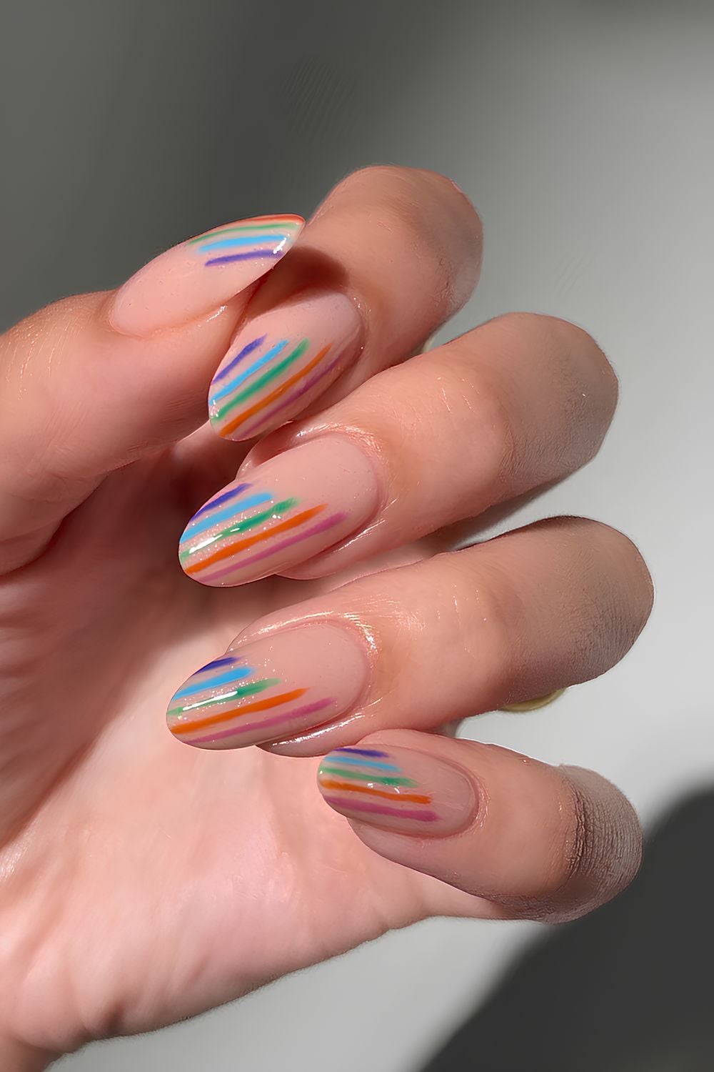 Neutral nails with glittery colorful stripes